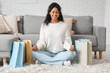 © Pixel-Shot - Happy young African-American woman meditating with shopping bags at home