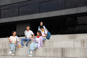 Canvas Print - Group of young students sitting near university