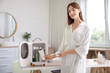 © Pixel-Shot - Beautiful young woman taking cosmetics from small refrigerator in bathroom