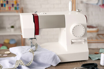 Wall Mural - Modern sewing machine with fabric and tailor's supplies on table in atelier