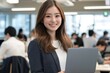 © Ganesha88 - Smiling Japanese businesswoman standing in an office, holding her laptop. She is wearing casual clothes, and other people working behind her are blurred.,generated ai.