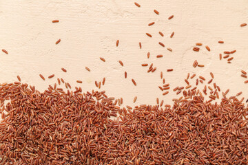 Wall Mural - Raw brown rice on beige background