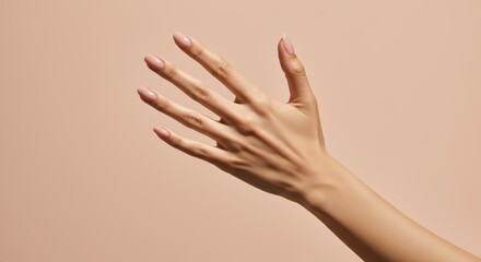 Elegant caucasian female hand with manicured nails against beige background