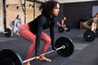 © Flamingo Images - Fit young woman lifting weights in a gym class