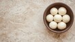 © JuanB - Rustic bowl filled with round white candies on a textured surface
