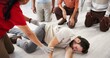 © peopleimages.com - People, demonstration and class for first aid, teaching or recovery position to prevent aspiration. Floor, life saving and learning to rescue person with seizure, healthcare or side technique for CPR