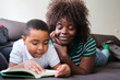 © Ladanifer - Mother and son bonding over a book on a cozy couch
