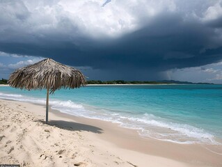 Wall Mural - Beach summer marketing campaigns concept. A serene beach scene with a thatched umbrella, turquoise waters, and dark clouds looming in the sky.