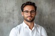 © c80 - Confident young man with glasses poses for a portrait against a concrete wall in natural light