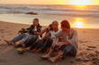 © bernardbodo - Friends drinking beer at sunset on beach, enjoying vacation together