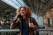 © bernardbodo - Happy tourist talking on smart phone at train station in madrid