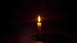 © HK - A single candle burning on an antique wooden table in a dark empty room, wax dripping slowly, image related to single awareness day