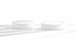 © Siasart Stock - Two White Cylinder Podiums Stand on a White Surface with Soft Shadows Gently Falling Across Them