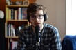 © vasyl pshyk - Young podcaster shares insights on mental health while surrounded by inspirational books in a cozy setting. Generative AI