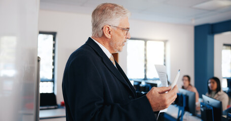 Fototapete - Mature man, teacher and lesson with whiteboard in classroom for presentation, education or learning. Male person, professor or lecturer teaching with curriculum or students for higher education