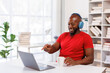 © David - African businessman wear headphones work on laptop.chatting online something video call to friends or relatives,