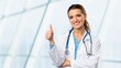 © ole - Cheerful Female Doctor Giving Thumbs Up Gesture in Modern Healthcare Environment