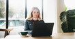 © peopleimages.com - Woman, laptop and remote work at cafe for drink, latte or cappuccino with freelance copywriting job. Person, computer and reading with tea cup for review, project or editing process at coffee shop