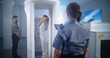 © Framestock - Airport Terminal: Woman Passes Through Metal Detector Scanner Gates on Security Checkpoint. Female Security Officer Checks Passenger, Ticket for Boarding Plane Flight. Diverse Travelers Going on Trips