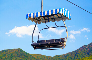  cable cars ascends through a  forest of autumnal in Seoul Grand Park, Korea.  The view showcases the serene beauty of the mountain landscape.