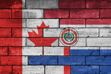 Wall Mural - colourful painted big flag of canada and flag of paraguay on a massive old brick wall background. concept