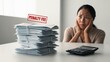 © saokaew - A worried woman sits by a stack of papers labeled 'PENALTY FEE,' indicating distress over financial obligations or late payments.