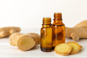 Wall Mural - Ginger essential oil on texture background. Fresh ginger slices. Essence, serum, oil. Alternative medicine. Phytotherapy. Health and beauty concept. Place for text. Copy space.