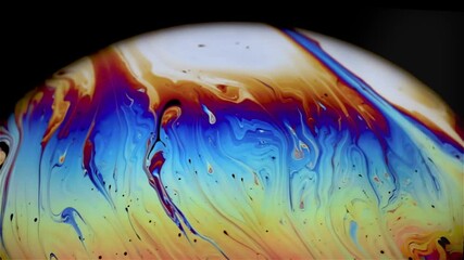 Wall Mural - Closeup video of a soap bubble showing thin film interference concept and the resulting different colors of light with each moving and swirling shapes. Perfect for illustrating concepts of physics.