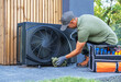 © Tomasz Zajda - Technician Performs Maintenance on Outdoor Air Conditioning Unit