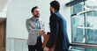 © HockleyM3/peopleimages.com - Collaboration, handshake and meeting with business people at window in office for partnership. Agreement, deal and onboarding with happy employee men in professional workplace for friendly welcome