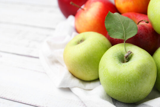 Wall Mural -  - different whole ripe apples on white wooden table, closeup. space for text