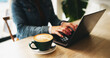 © peopleimages.com - Typing, hands and person with laptop, coffee shop and freelancer with project for content creation. Creative, entrepreneur and planning for article in cafe, writer or research for remote work on desk