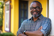 © Carmen - Portrait of mature African-American man standing in front of traditional house, home ownership concept