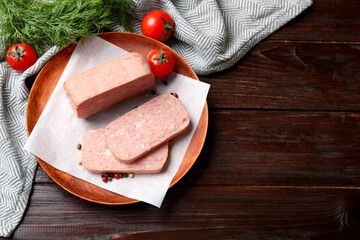 Wall Mural - Pieces of tasty canned meat, tomatoes, dill and peppercorns on wooden table, flat lay. Space for text