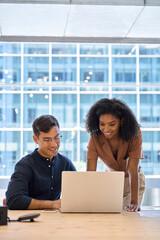Aufkleber - Two diverse employees professionals discussing financial data at corporate business meeting. Busy happy business people work team colleagues using laptop computer working together in office. Vertical.