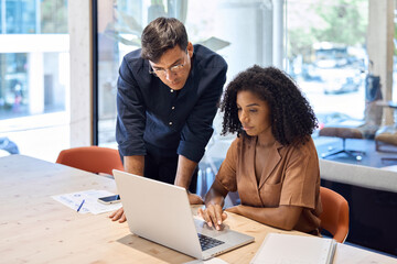 Aufkleber - Busy company manager consulting employee learning corporate software in office. Business team of two diverse young professional executives working together using laptop computer at work.