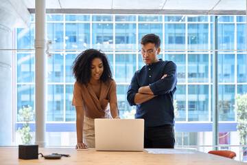 Aufkleber - Two busy business people man and woman working on computer discussing online project at work. Diverse professional workers team talking on financial technology or marketing data using laptop in office