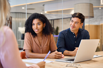 Aufkleber - African American female executive financial advisor consulting client at meeting. Busy young professional diverse business people employees team having conversation working together at office table.
