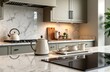 © Vadym - Stylish modern kitchen interior shows off marble-looking quartz countertop, backsplash. Cream electric kettle, porcelain tea accessories neatly arranged on counter next to ceramic hob. Clean,