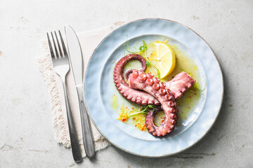 Wall Mural - Appetizing octopus tentacles served on light table, top view