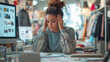 © scaliger - Stressed young woman in fashion studio struggling with deadlines, surrounded by computers and fashion designs