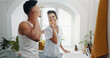 © CoetzeeRising/peopleimages.com - Brushing teeth, laughing and morning with couple in bathroom for dental hygiene or oral care. Happy, love and mirror with funny people in home together to prevent cavity or gum disease for health