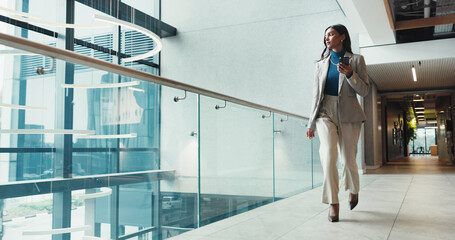 Fototapete - Corridor, phone and walking with business woman in office for arrival, communication or progress. App, social media and typing text message with Indian employee thinking in corporate workplace