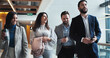 © peopleimages.com - Discussion, walking or business people in hallway for conference or convention in office. Leave, teamwork or keynote speaker with smile or staff in lobby for networking, seminar project and event