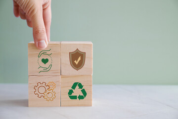 hands holding wooden blocks with hse and health, safety and environment icons, for preventing workpl