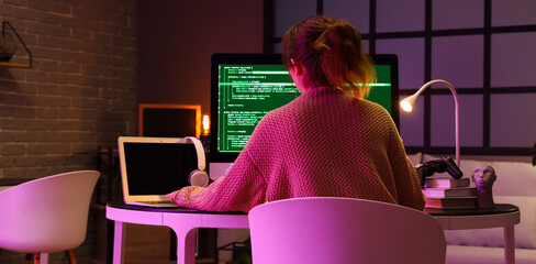 Wall Mural - female programmer working at table in office, back view