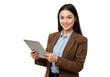 © stock.metket.com - A young woman in a brown blazer over a light blue shirt, holding a tablet and smiling