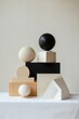 © KerXing - Aesthetic arrangement of geometric shapes in wood and stone, showcasing minimalist design on a white table.