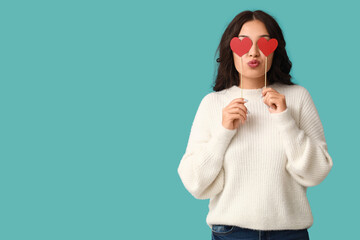 Wall Mural - Beautiful young Asian woman with red paper hearts on blue background. Valentine's Day celebration