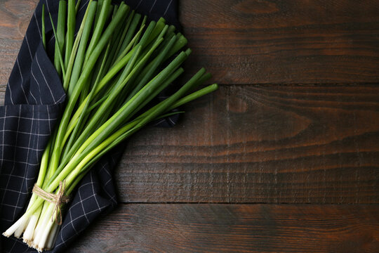 Wall Mural -  - bunch of fresh green onions on wooden table, top view. space for text